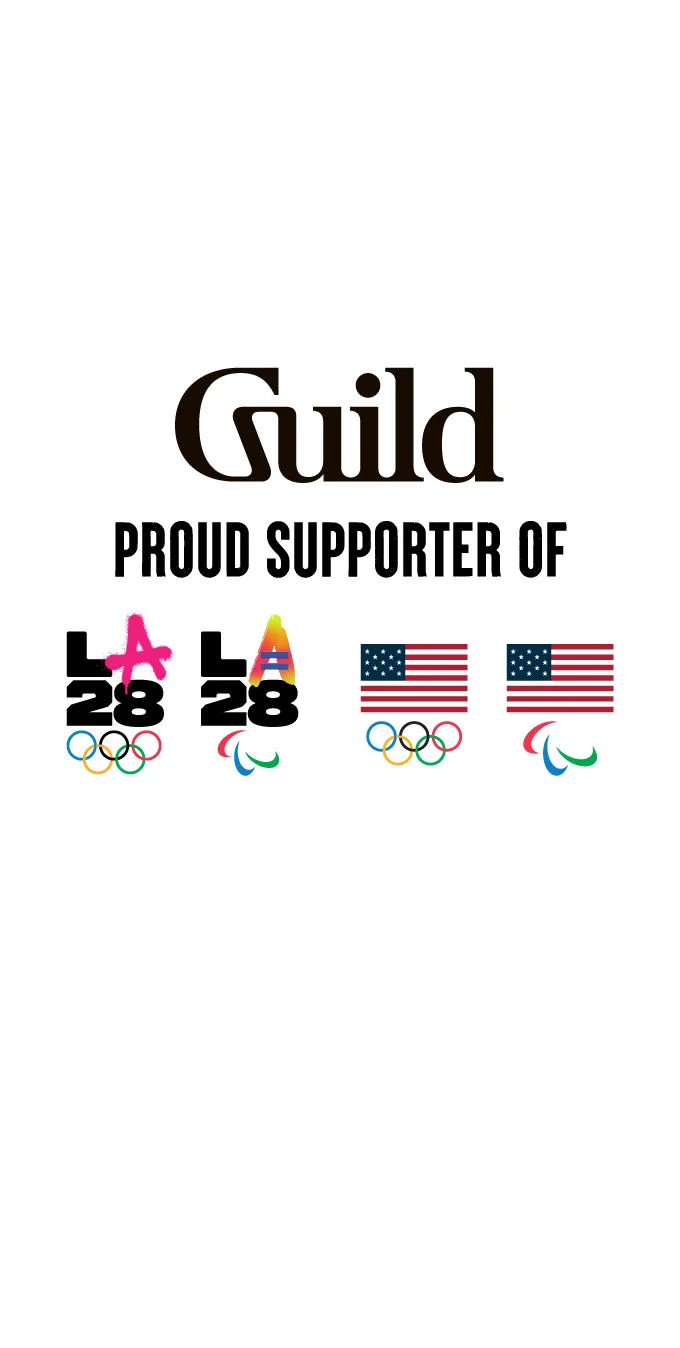 El logotipo de Guild, seguido por las palabras Orgulloso Partidario De, seguido por el doble emblema de LA28 con los Anillos Olímpicos y los Agitos Paralímpicos abajo de las letras L y A, enseguida del logotipo de Team USA con la bandera de los Estados Unidos arriba de los Anillos Olímpicos y los Agitos Paralímpicos 