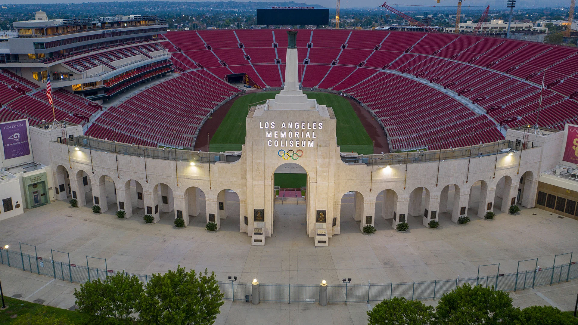 Fotografía de la entrada al LA Memorial Coliseum con asientos y gradas visibles en el fondo