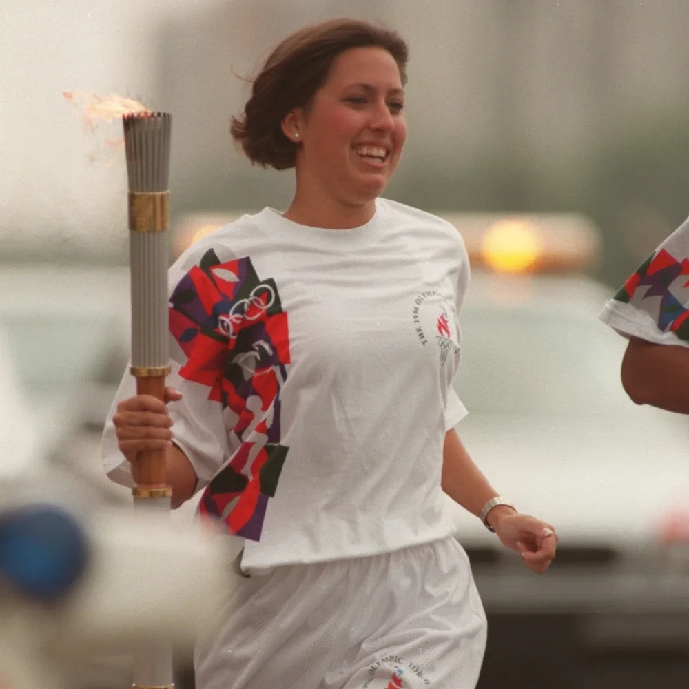 An image of Olympian Janet Evans holding the Olympic flame during the 1996 Atlanta Torch Relay.