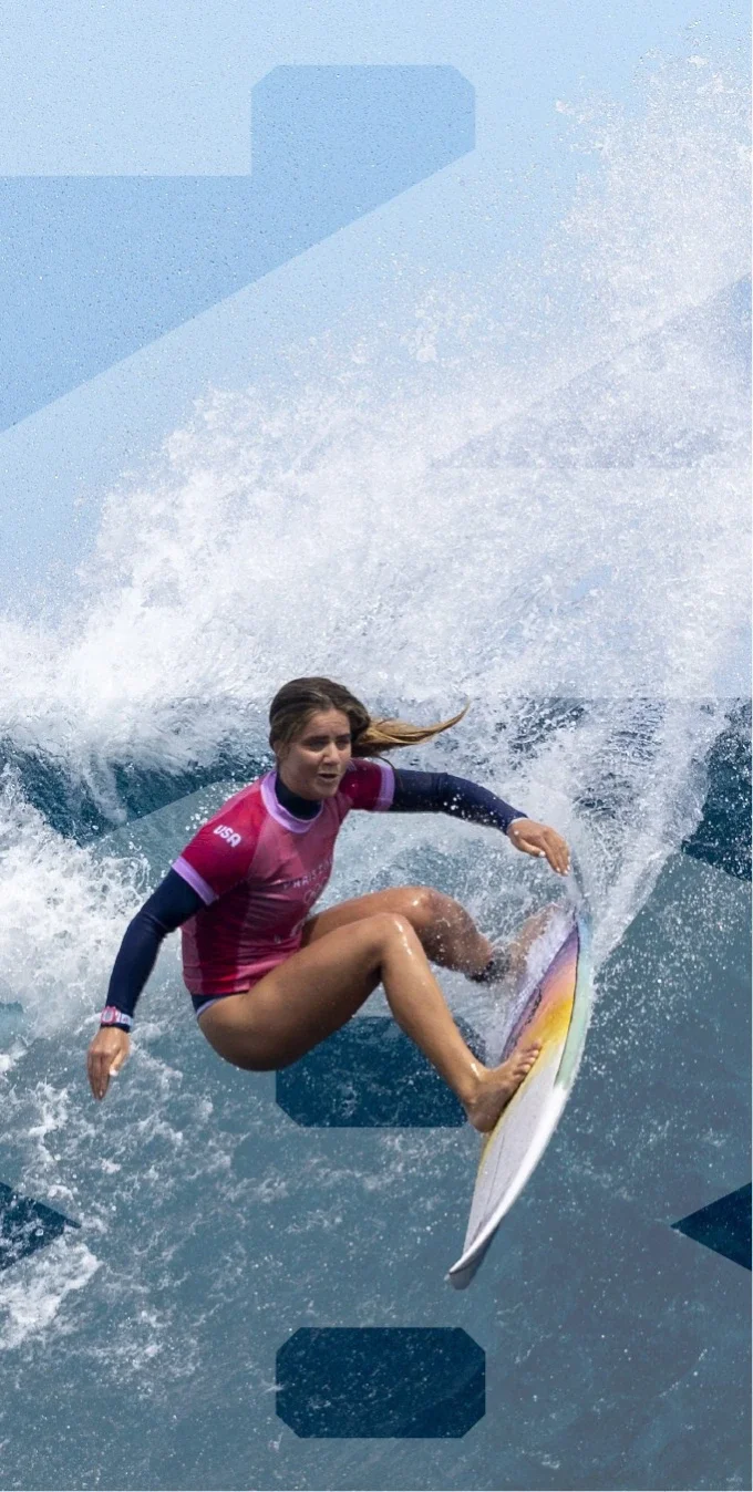 Photograph of a female surfer in a pink rashguard dropping in on a wave with the number 28 overlayed on top of the image