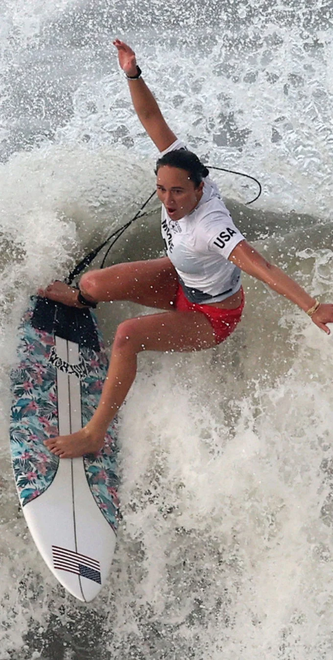 Carissa Moore surfeando sobre una tabla de surf