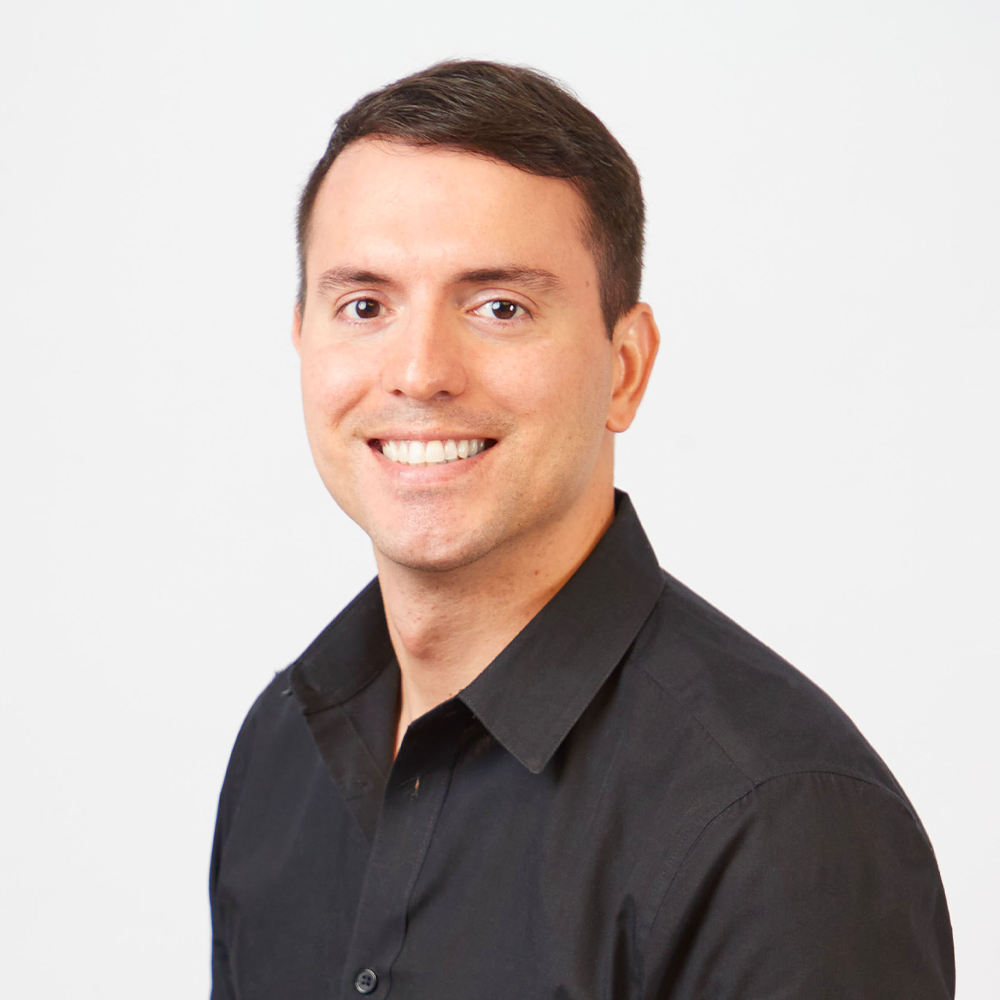 LA28 staff member Octavio Alesi smiling while wearing a black button up shirt 