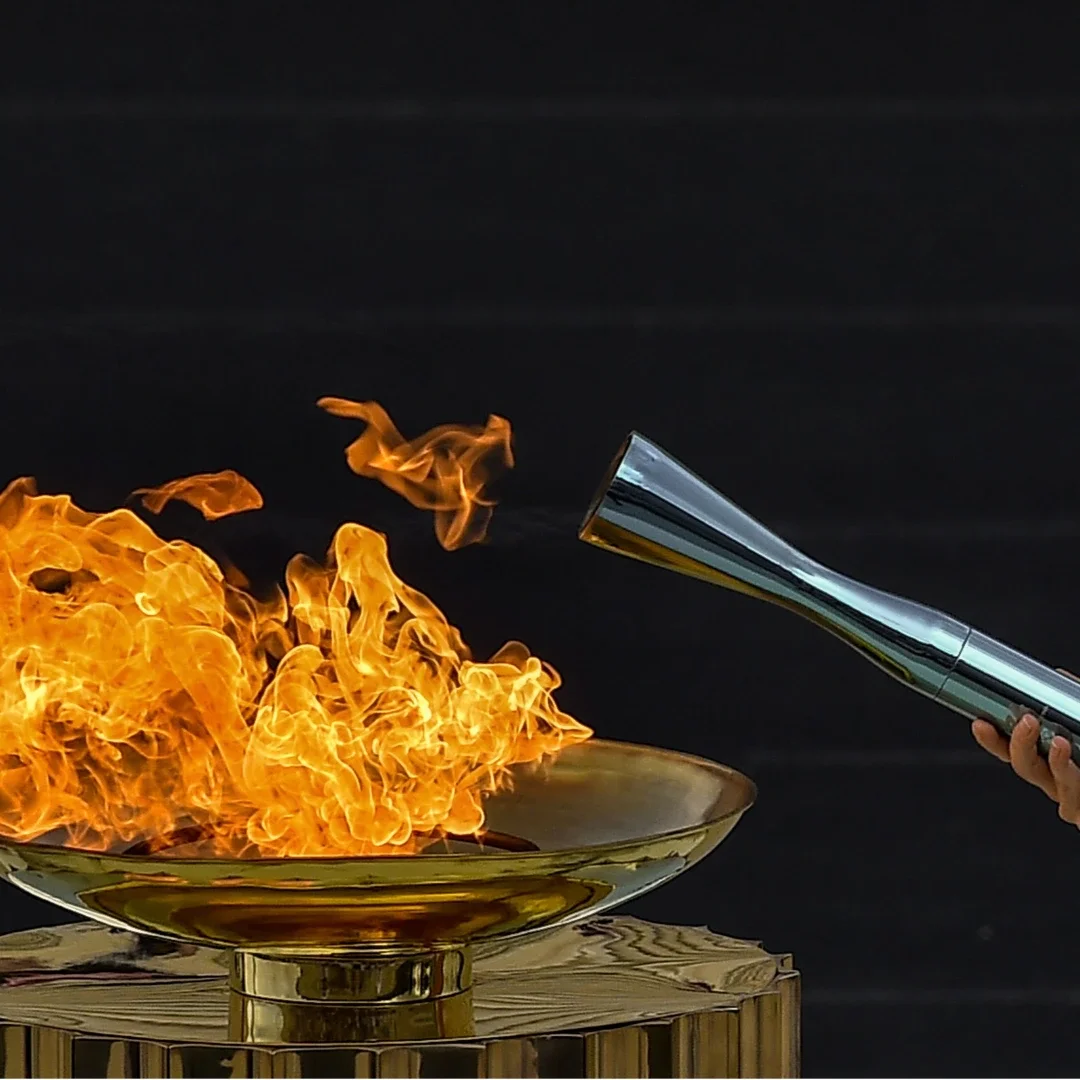 Torch cauldron being lit for the torch relay with a hand sticking out
