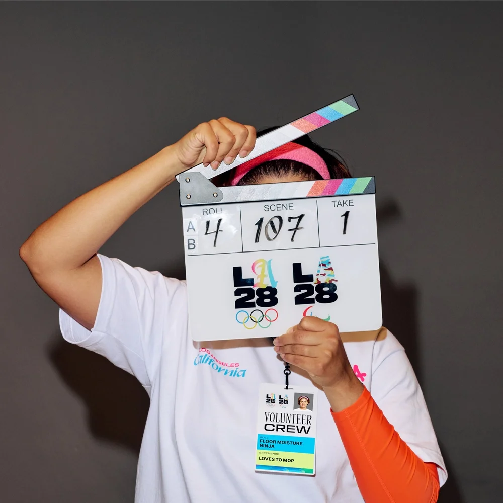 LA28 games-time volunteer posing with clapboard