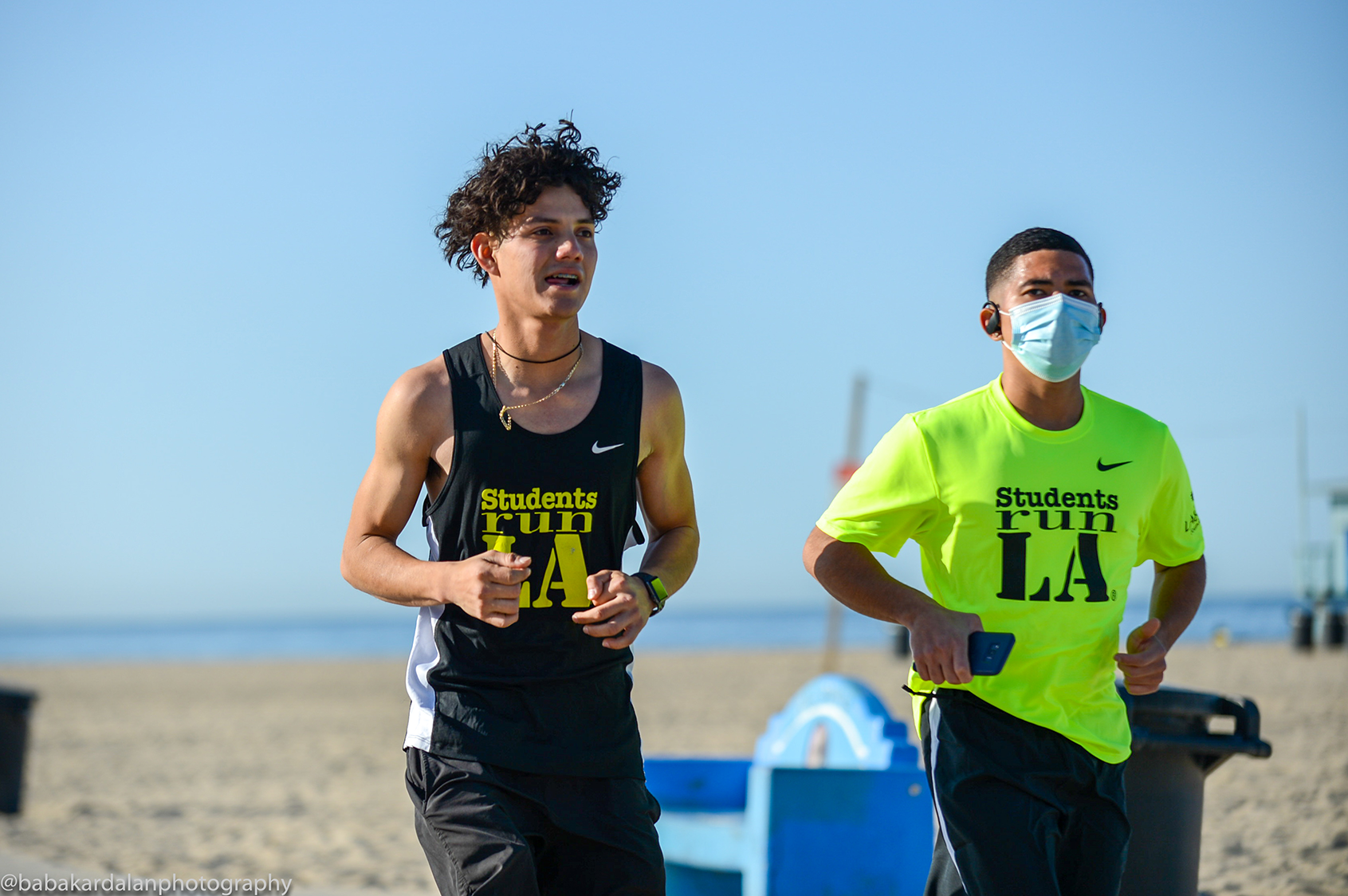 Photo graphic of two young men running side by side wearing shirts that say Students Run LA and text on the graphic that say Student Runners Across LA show the Power of Sport