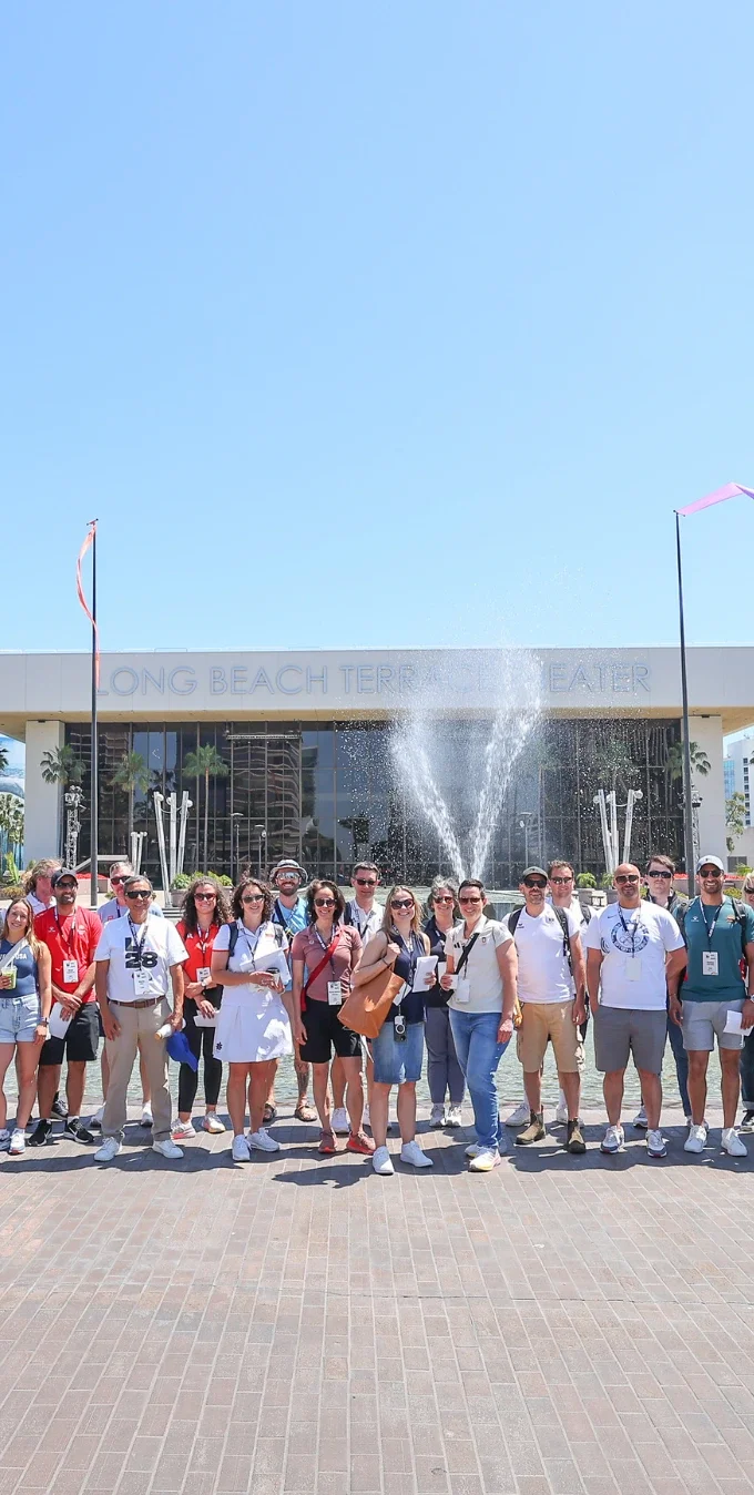 Photograph of a group of LA28 staff and international delegates from various National Olympic Committees standing in front of the Long Beach Theater for the 2025 Open Day for National Olympic Committees.