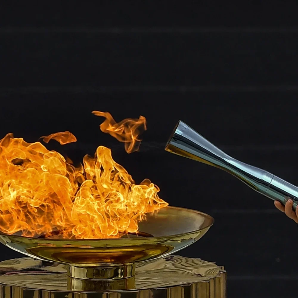 Lighting of a cauldron and the Olympic torch with a hand sticking out
