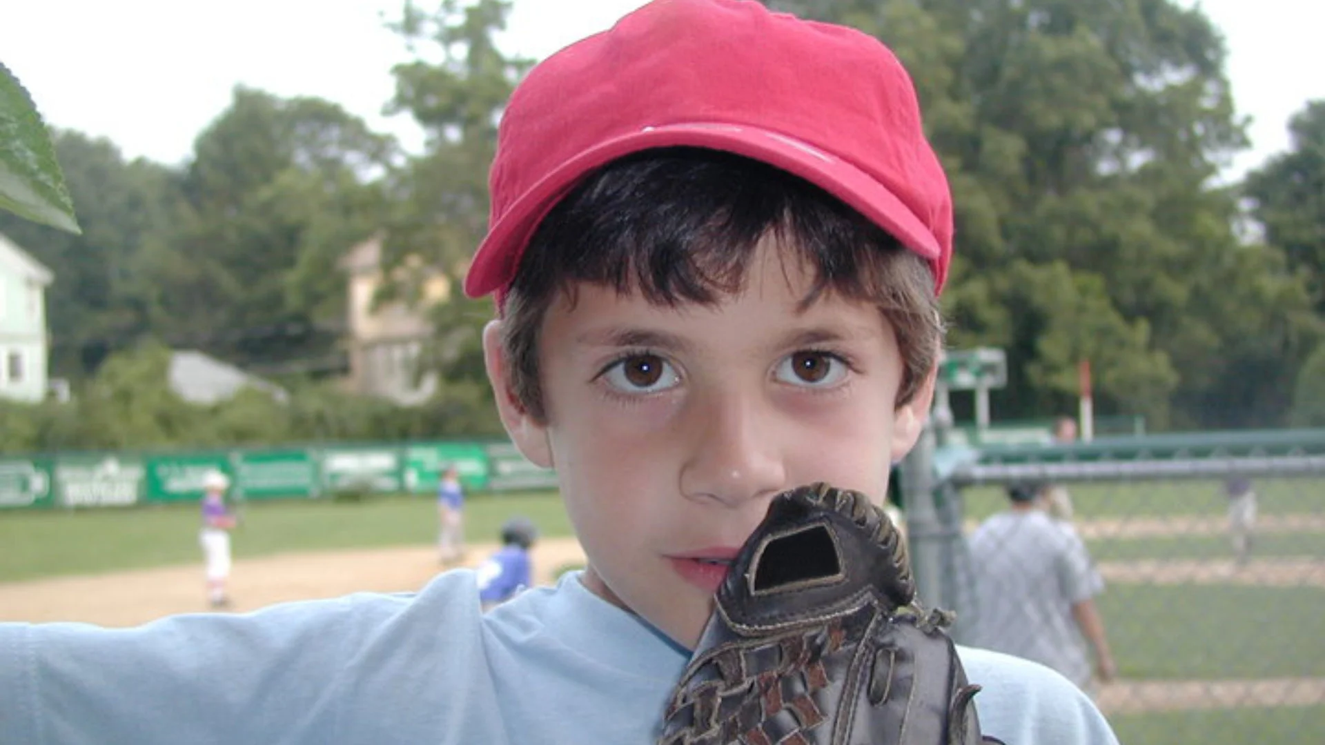 Photo of Ben as a kid wearing a baseball glove