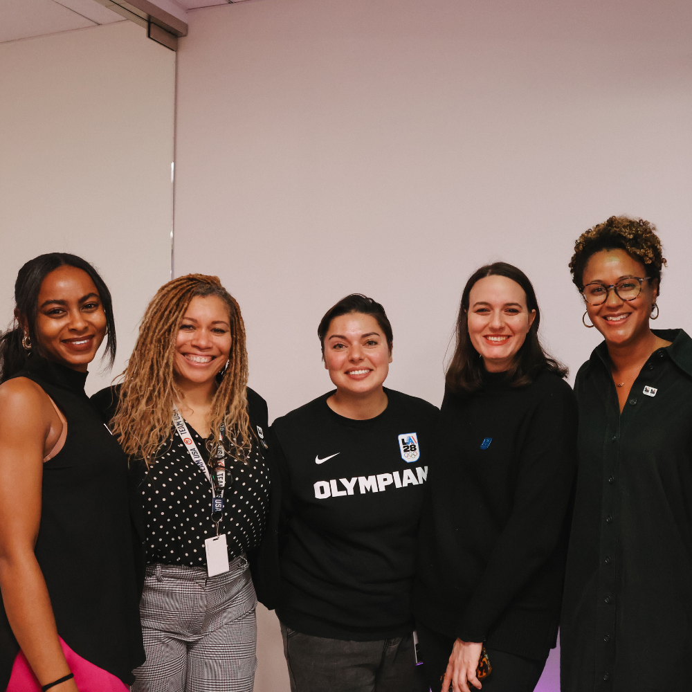 Photo of five woman from the LA28 staff standing next to eachother and smiling for a photo