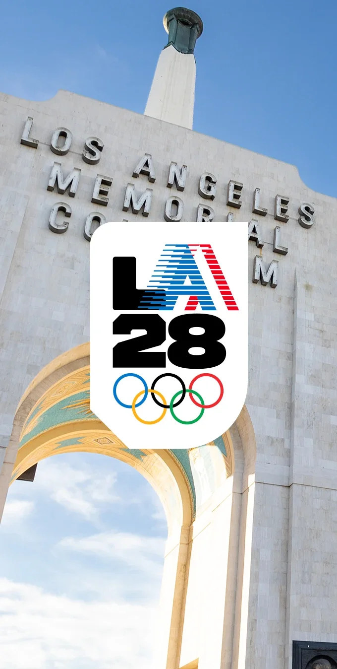 Fotografía del Coliseo Memorial de Los Ángeles con la “A” retro sobre una forma blanca de escudo en el centro de la imagen.