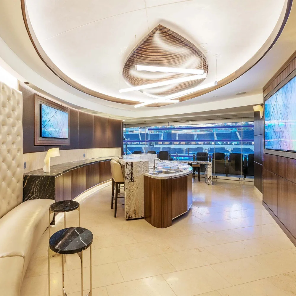 Vista desde un suite con asientos premium negros en primer plano y vista al campo de fútbol en el SoFi Stadium