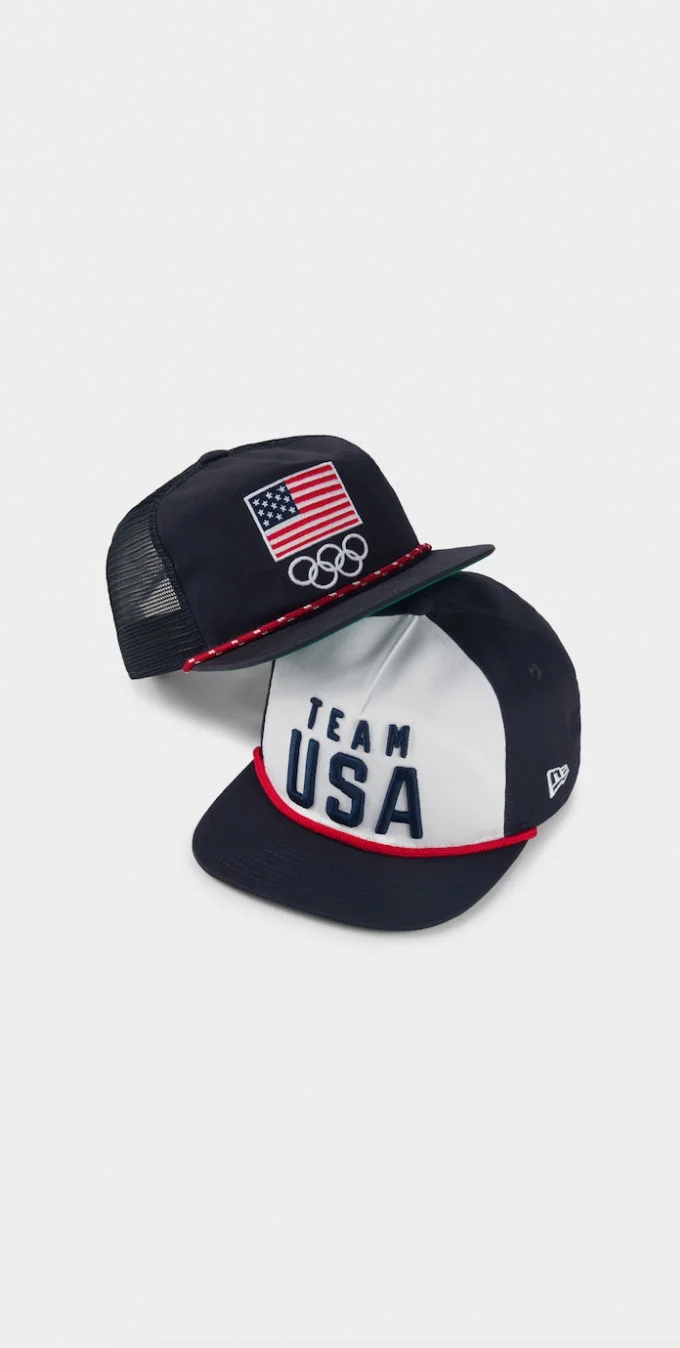 Foto de diferentes gorras New Era con varios diseños en rojo, blanco y azul y las palabras Team USA, Equipo Olímpico de los Estados Unidos, los anillos olímpicos o una bandera estadounidense bordados en ellas.