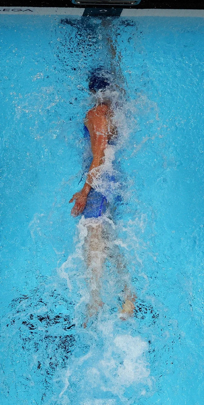 Photograph of male swimmers in a pool.