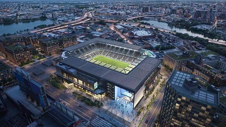 Rendering of New York Stadium, known as Etihad Park, showing the soccer stadium from above with urban buildings and city streets surrounding the building. In the foreground are fans entering the stadium.  
