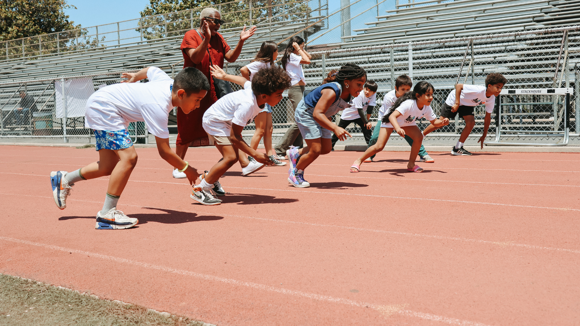 Photo showing kids from playla taking off in a race on track wearing la28 shirts