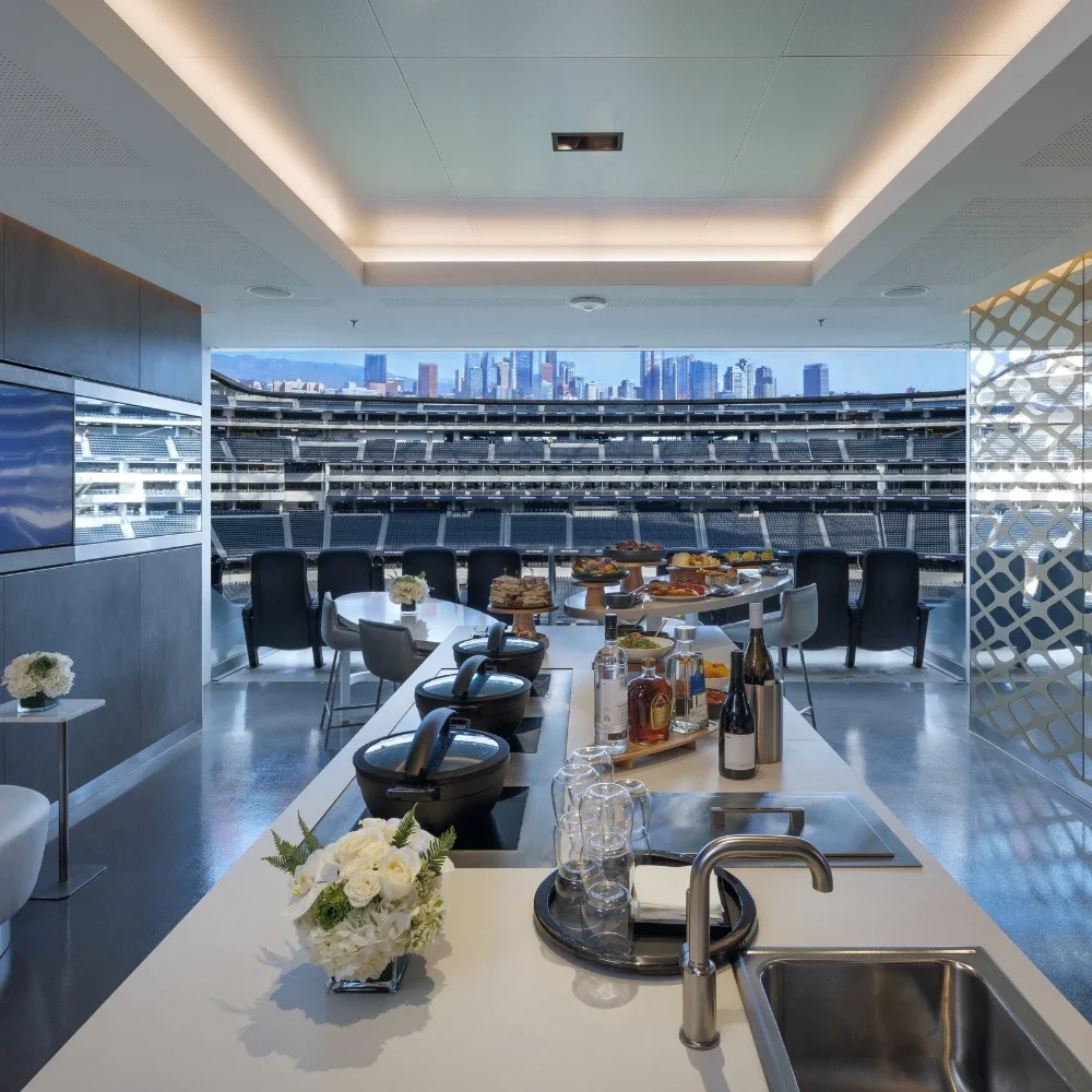 A photograph showing a hospitality suite at Sofi Stadium with the football field in the background
